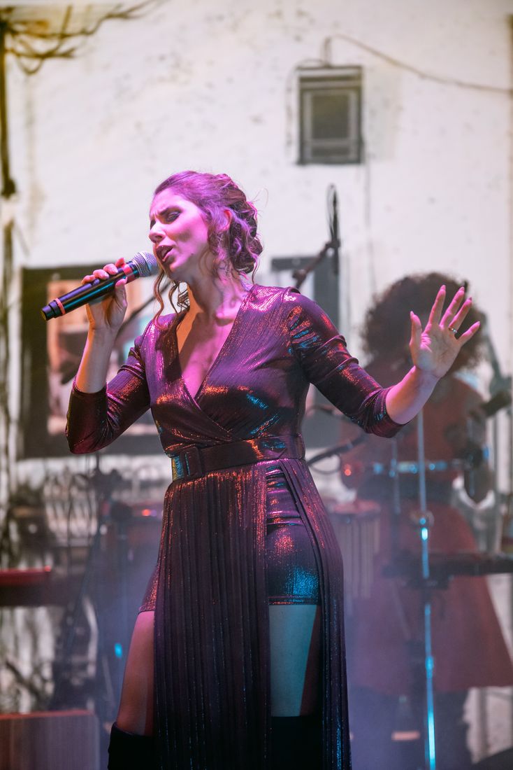 Lasimi sul palco in abito lucido, luci viola